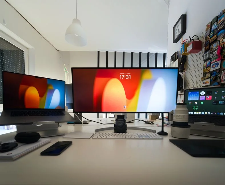 High-angle view of a stylish work desk featuring dual monitors, keyboard, mouse, and modern accessories.
