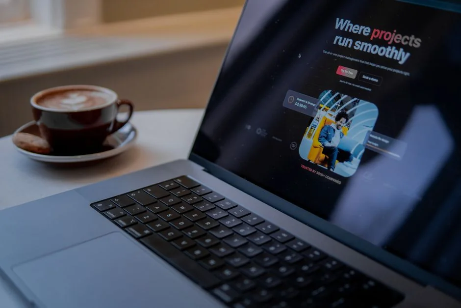 A laptop on a bed showing web design software, creating a cozy workspace.